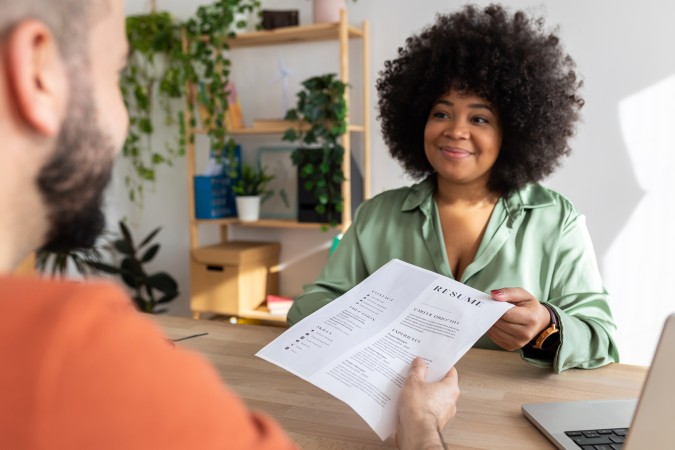 une femme donne son CV pour être embauchée par un auto-entrepreneur